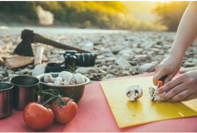 Scout slicing a mushroom on a yellow cutting board.