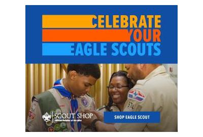 A male Eagle Scout being presented with a badge by a Scoutmaster.