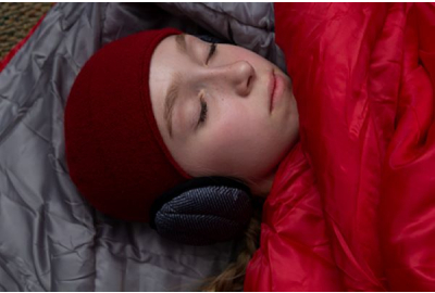 Scout sleeps in a red sleeping bag inside a tent.