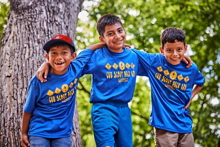 3 Cub Scout boys pose for a picture in blue Cub Scout tees.