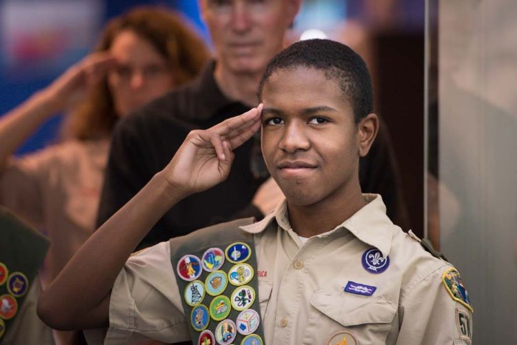 Boy Scout salutes during an Eagle Scout Court of Honor ceremony
