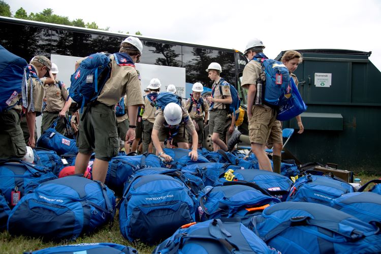 Scouts unloading blue gear bags from a bus at the 2017 National Jamboree