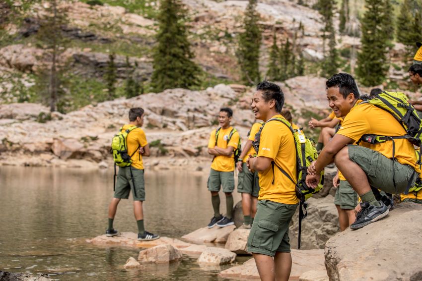 Outdoor Adventure Activities for Scouts by a Mountain Lake | Hiking and Teamwork in Nature. Scouts by a mountain lake hiking and enjoying outdoor adventure activities surrounded by nature and rocky terrain.