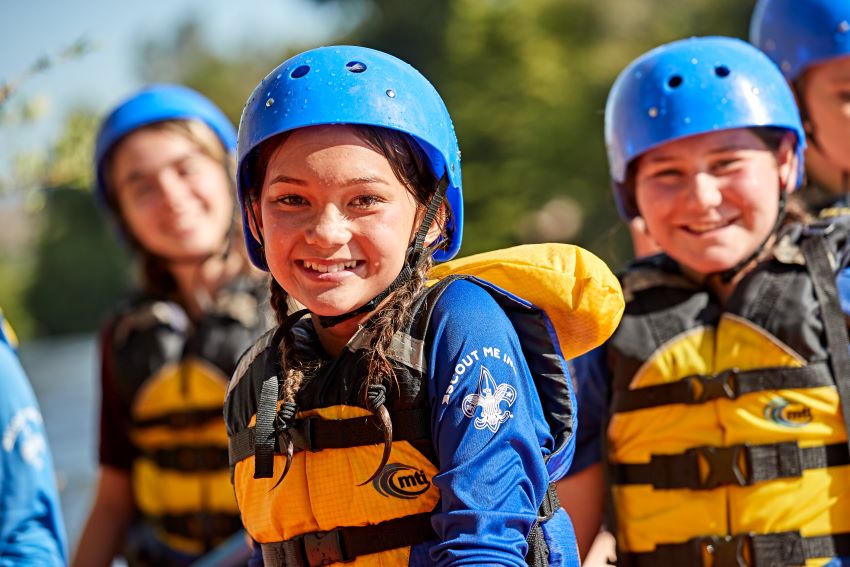 Scouts Water Safety Activities | Outdoor Adventure for Youth with Helmets and Life Vests. Scouts wearing blue helmets and yellow life vests, smiling during water-based outdoor activities promoting safety and teamwork.