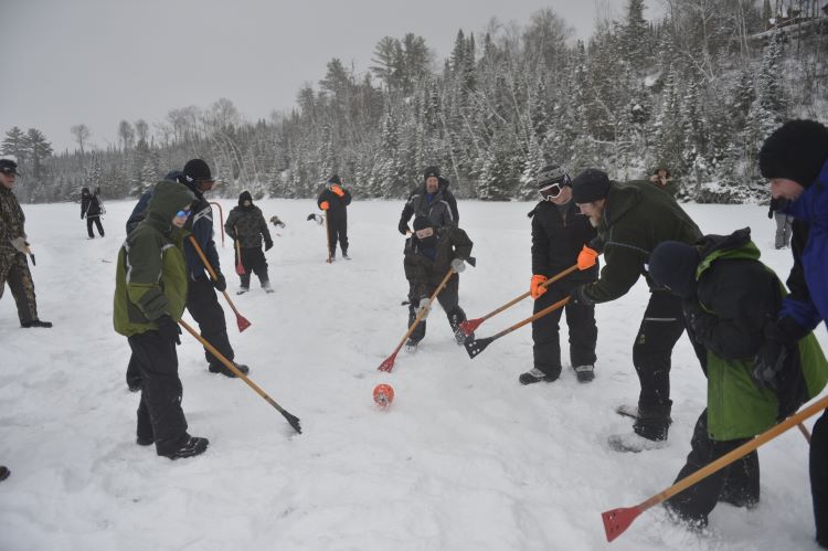 Scouts play a game of field hockey in the snow