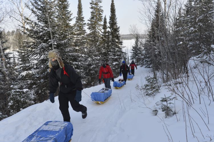 Scouts transporting backpacks on sleds